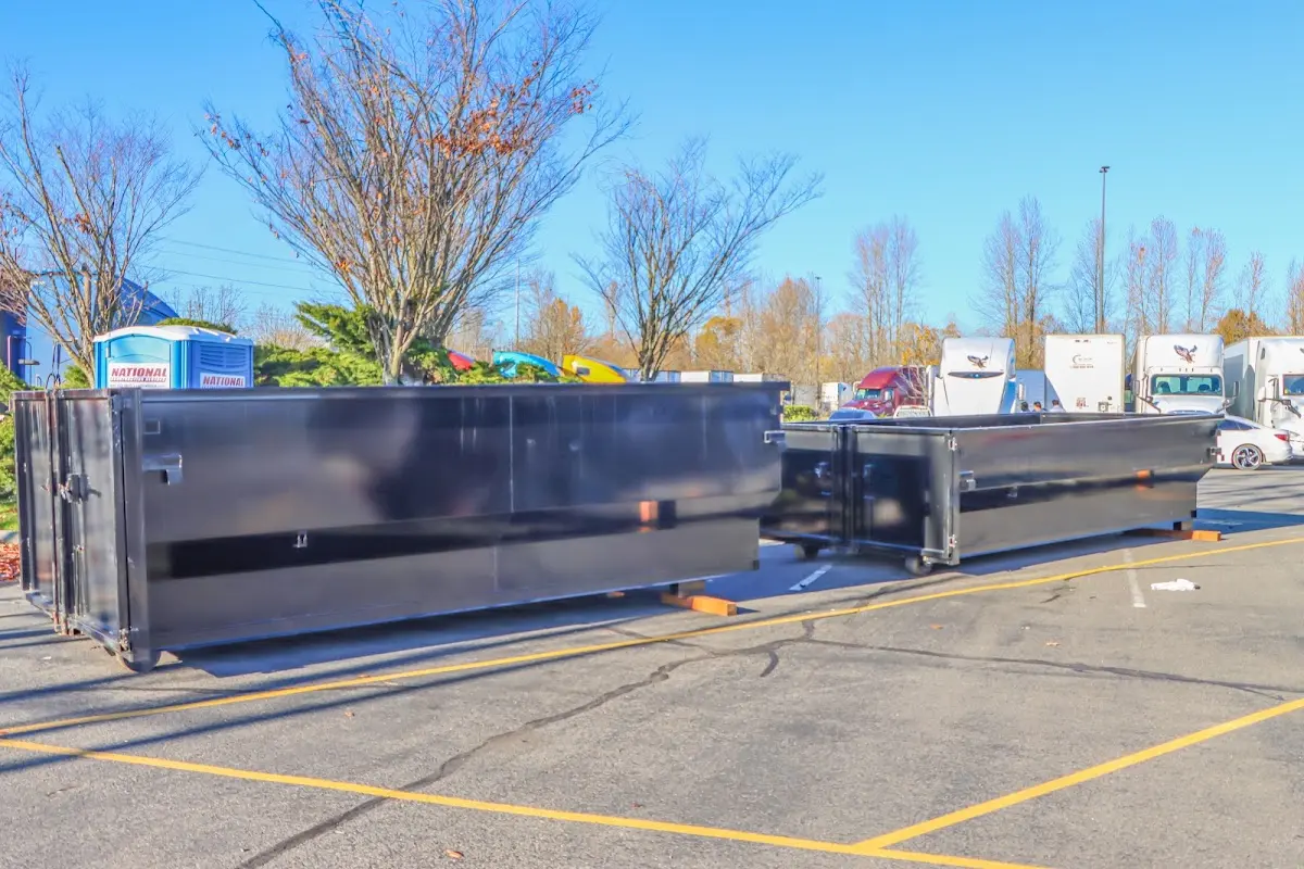 Professional dumpster rental service with roll-off container on residential driveway in Columbine